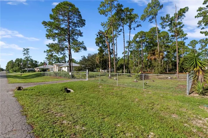 Enormous chain link fenced 1 acre yard space located on a dead end road with tons of mature trees and second gate access with driveway culvert
