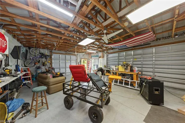 Detached 24'x40' 3 car garage/workshop with a metal roof, 30 amp service, front facing and side load garage doors, bright overhead work lights, fans for circulation, epoxy coated floors, tons of outlets throughout for running tools