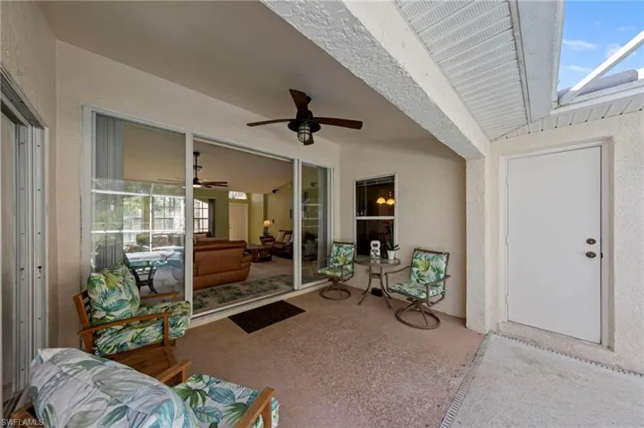 Screened lanai under truss overlooking pool and door to pool bath