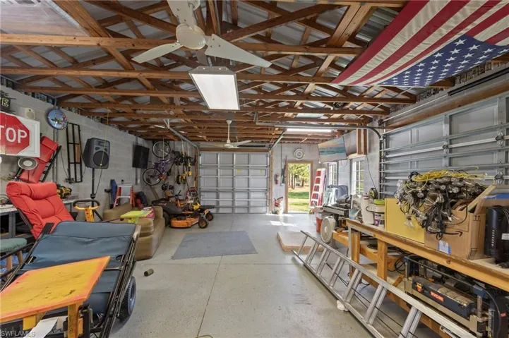 Detached 24'x40' 3 car garage/workshop with a metal roof, 30 amp service, front facing and side load garage doors, bright overhead work lights, fans for circulation, epoxy coated floors, tons of outlets throughout for running tools