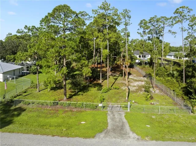 Enormous chain link fenced 1 acre yard space located on a dead end road with tons of mature trees and second gate access with driveway culvert