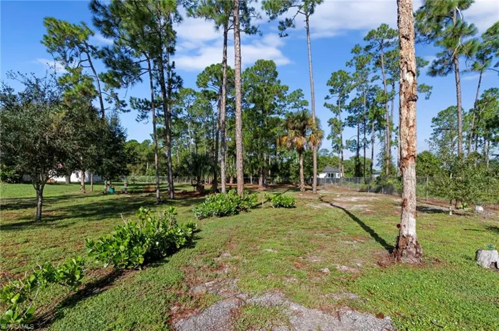 Enormous chain link fenced 1 acre yard space located on a dead end road with tons of mature trees and second gate access with driveway culvert