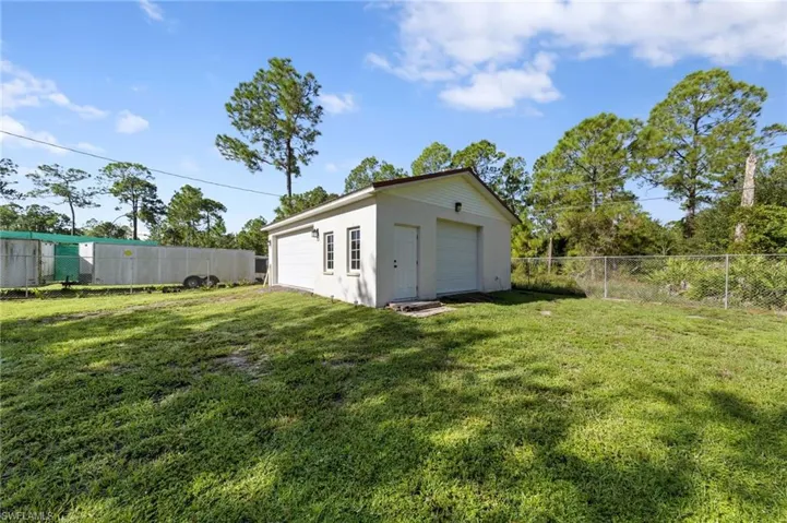 Detached 24'x40' 3 car garage/workshop with a metal roof, 30 amp service, front facing and side load garage doors, bright overhead work lights, fans for circulation, epoxy coated floors, tons of outlets throughout for running tools