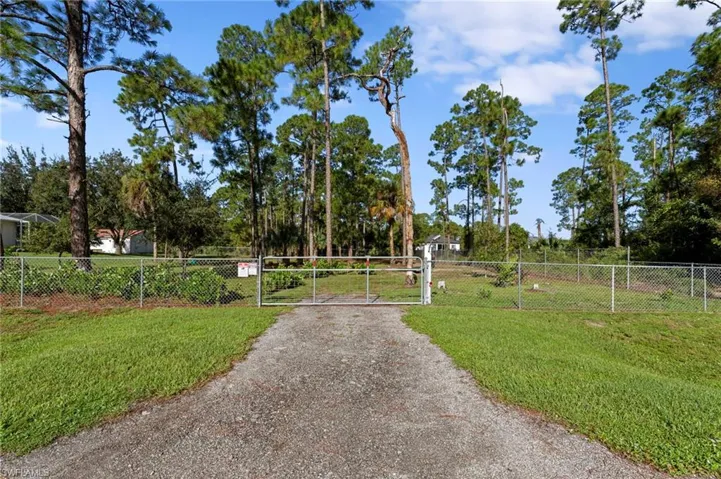 Enormous chain link fenced 1 acre yard space located on a dead end road with tons of mature trees and second gate access with driveway culvert