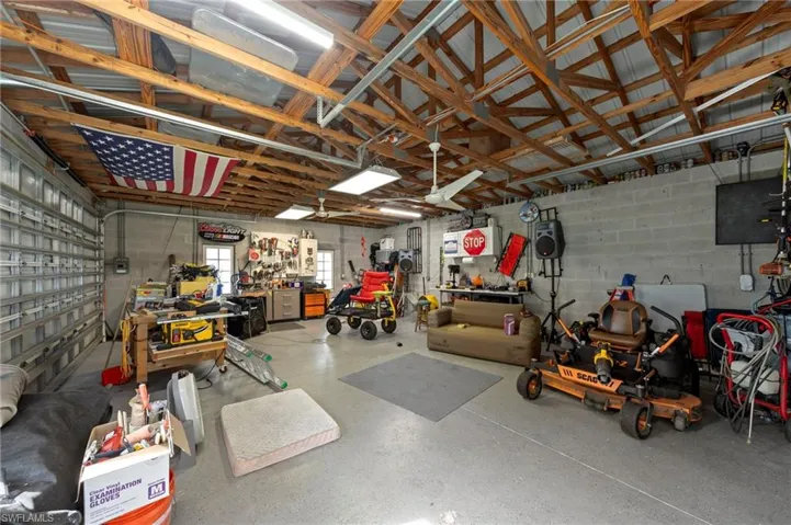 Detached 24'x40' 3 car garage/workshop with a metal roof, 30 amp service, front facing and side load garage doors, bright overhead work lights, fans for circulation, epoxy coated floors, tons of outlets throughout for running tools
