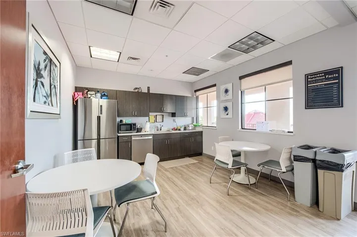 Kitchen featuring stainless steel appliances, a drop ceiling, light countertops, and dark brown cabinetry
