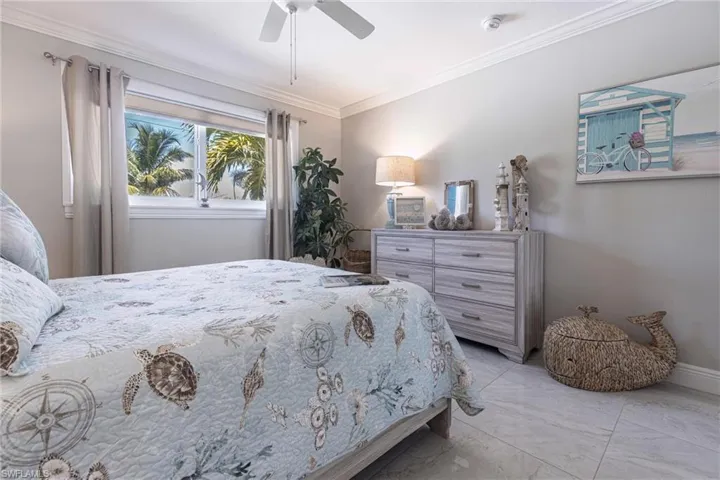 Bedroom with baseboards, marble finish floor, ornamental molding, and ceiling fan