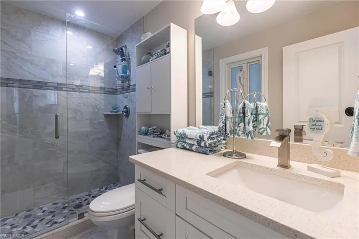 Full bathroom with a stall shower, toilet, and vanity