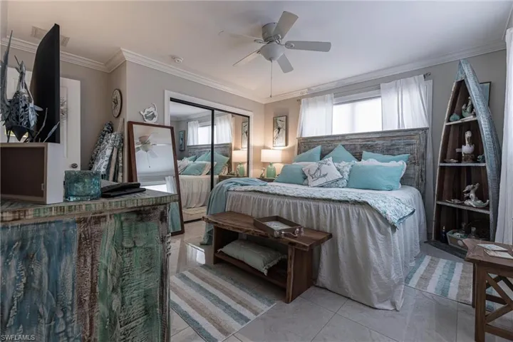 Bedroom with ornamental molding, a closet, and ceiling fan