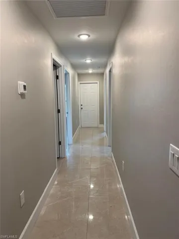 Hallway with baseboards and light marble finish flooring