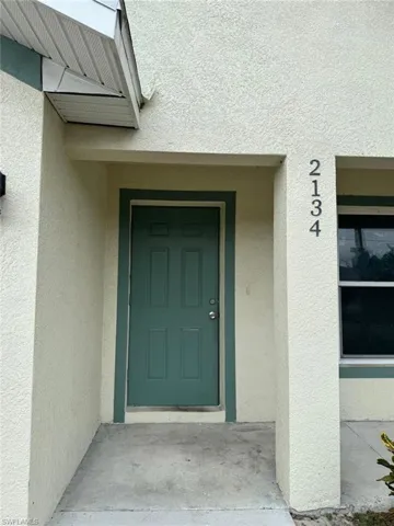 Doorway to property featuring stucco siding