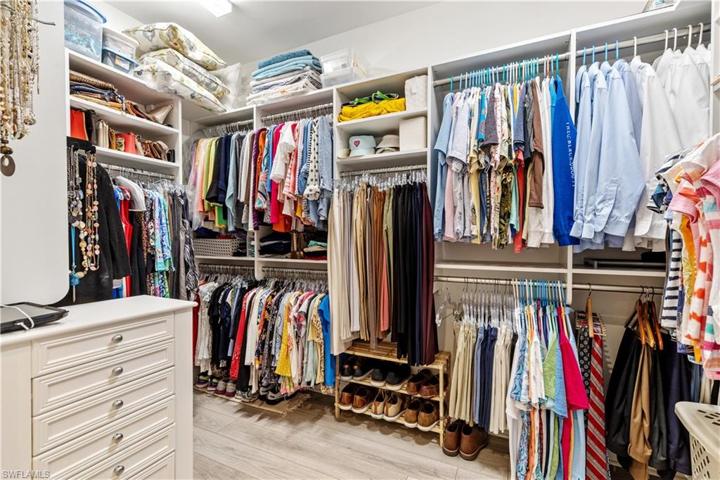 Large primary walk in closet with built in shelving