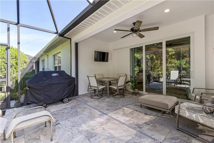 Extended lanai with travertine tile.  Mounted television is included.