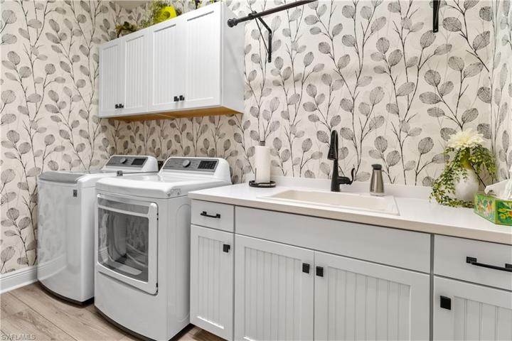 Laundry room with sink, quartz counter, wood cabinets and upgraded fixtures