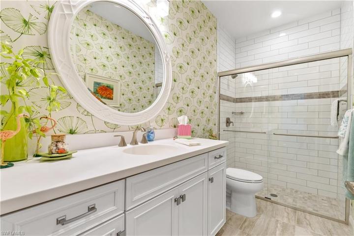 Guest Bath with quartz counter, wood cabinets, upgraded tile and designer mirror