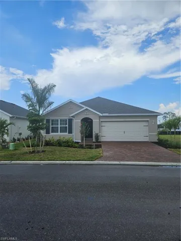 Ranch-style house with decorative driveway, an attached garage, and stucco siding