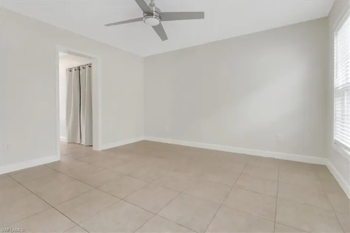 Bedroom with tiled floors, a healthy amount of sunlight, baseboards, and ceiling fan