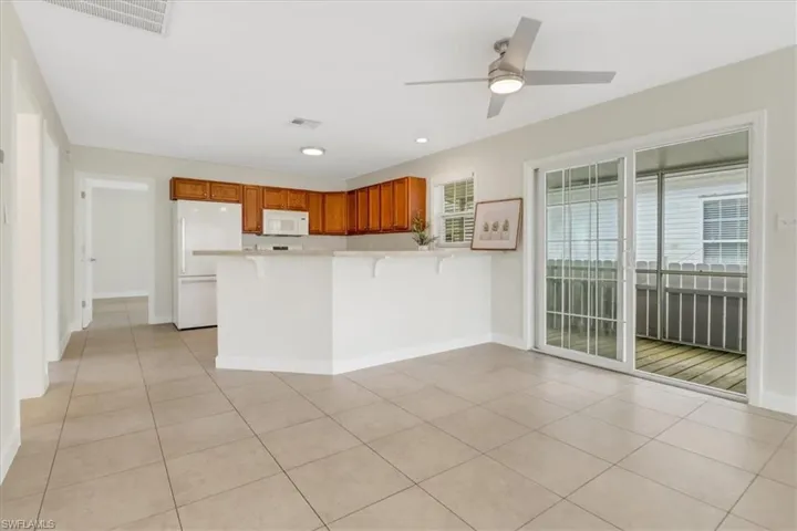 Kitchen with light countertops, light tile patterned floors, a peninsula ,wood cabinetry and new appliances