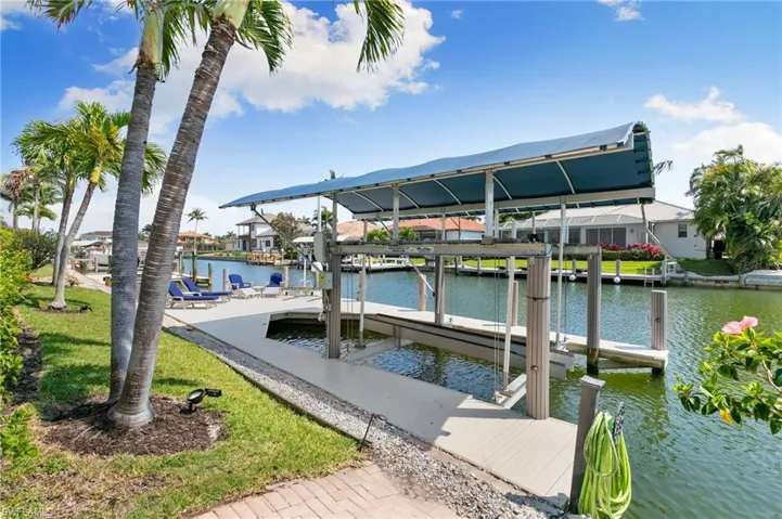 View of dock with boat lift and a water view