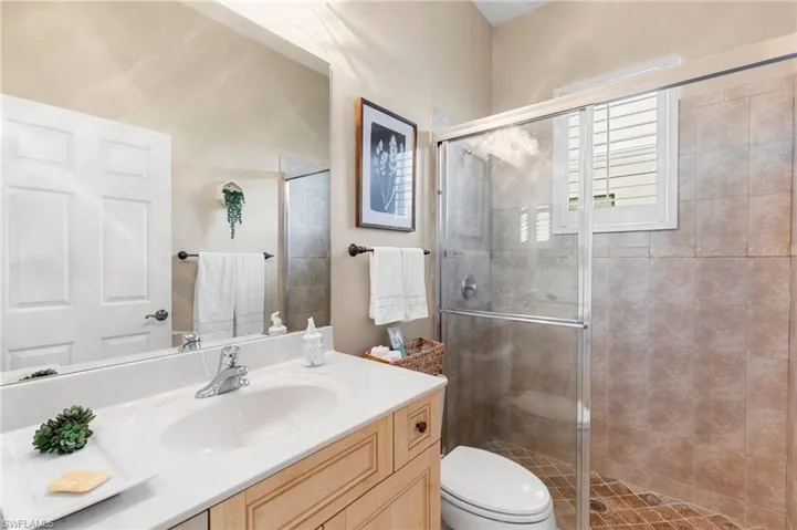 Bathroom featuring vanity, a shower stall, and toilet