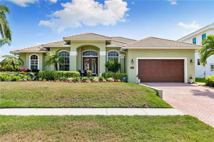 Mediterranean / spanish home featuring stucco siding, a tile roof, decorative driveway, and a garage