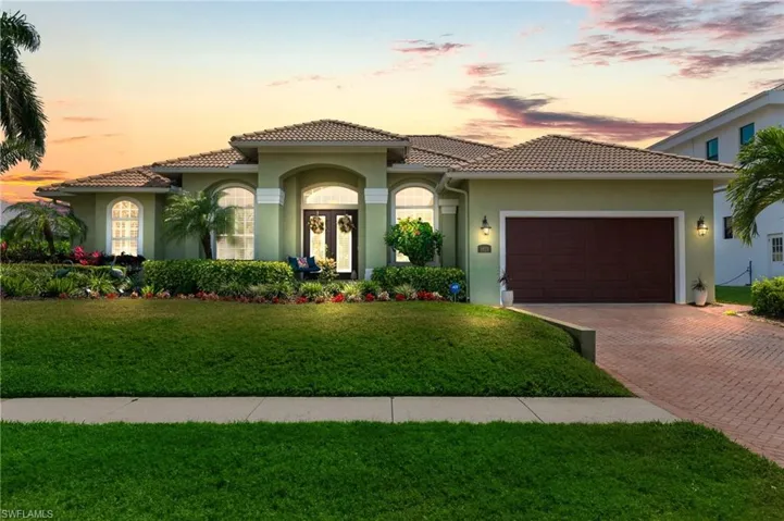 Mediterranean / spanish home featuring stucco siding, an attached garage, decorative driveway, and a tiled roof