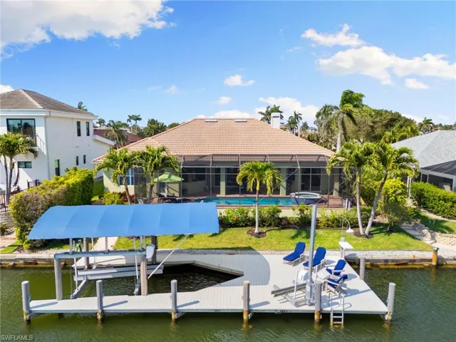 View of dock featuring glass enclosure, a water view, and boat lift