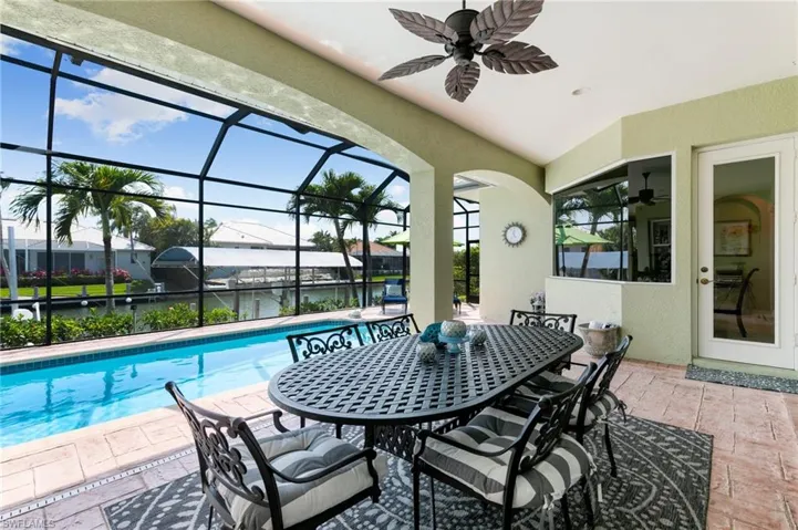 View of patio / terrace with an outdoor pool, a lanai, a ceiling fan, and outdoor dining space