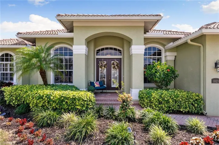 Doorway to property featuring french doors, a tile roof, and stucco siding