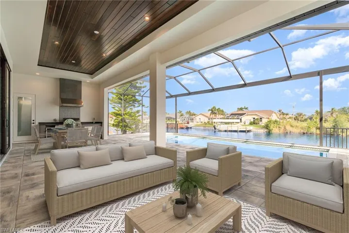 This massive lanai with living area and summer kitchen is highlighted with a wood tray ceiling.