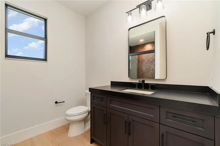 3rd Full bath featuring a shower stall, vanity, and light wood plank tile flooring