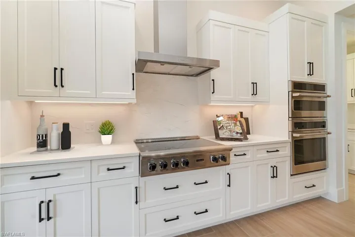 Kitchen featuring a 36" cooktop, stainless steel exhaust hood, wall oven and microwave