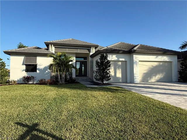View of front facade featuring decorative driveway, stucco siding, a front lawn, french doors, and an attached garage