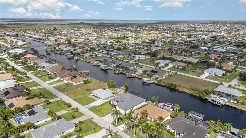Aerial view of property's location featuring a large body of water and nearby suburban area