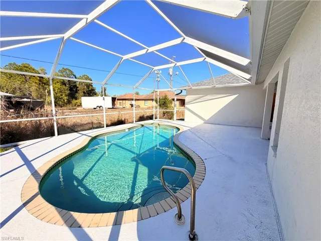 View of pool featuring a sunroom, a lanai, and patio surround