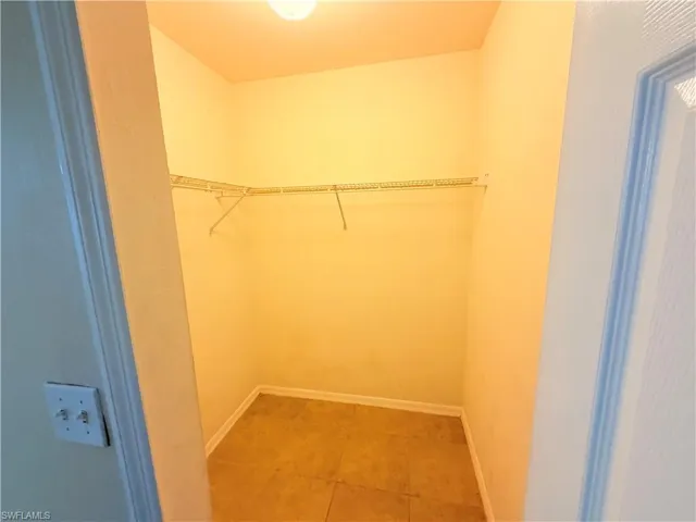 Walk in closet with light tile patterned flooring