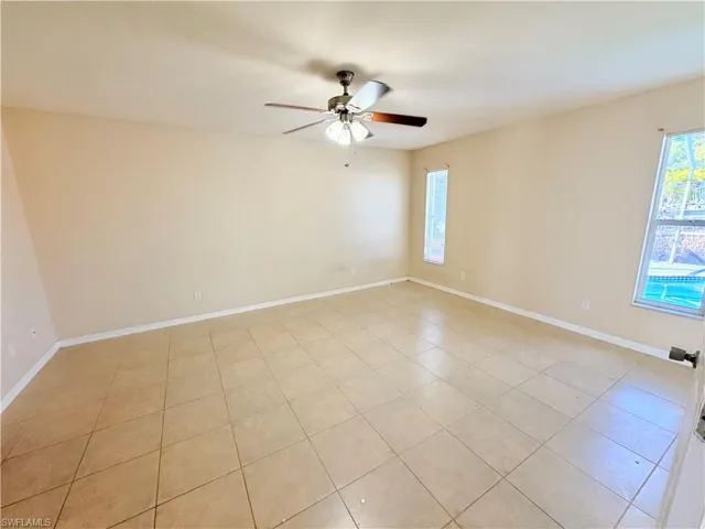 Unfurnished room featuring plenty of natural light, ceiling fan, and light tile patterned flooring