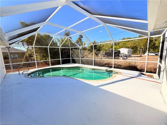 Swimming pool with a patio, a lanai, and a sunroom