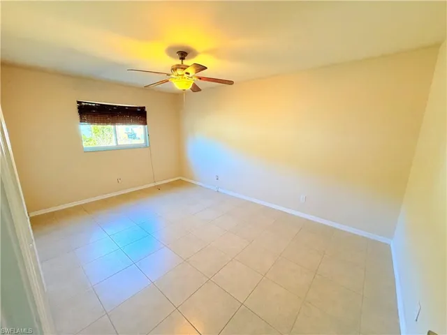 Spare room with ceiling fan and light tile patterned floors