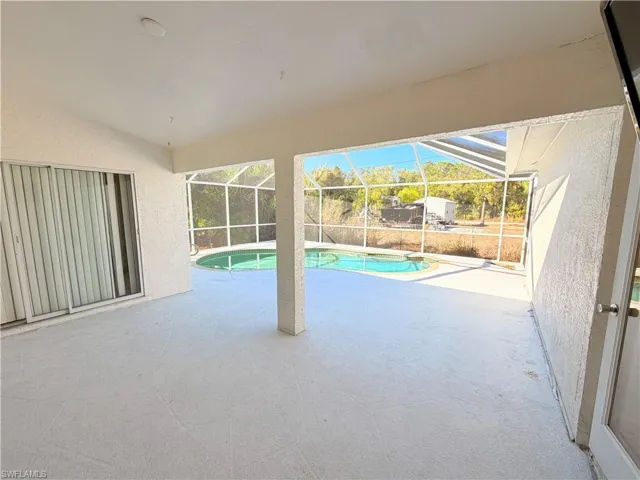 Swimming pool featuring a patio area, a lanai, and a sunroom