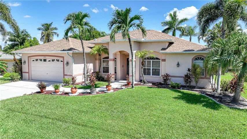 View of front of house with a garage and a front yard