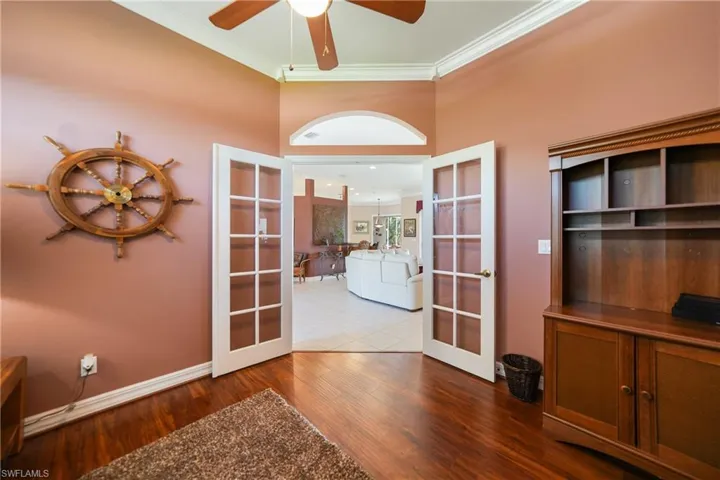 Unfurnished office featuring washer and clothes dryer, french doors, tile patterned floors, ceiling fan, and ornamental molding