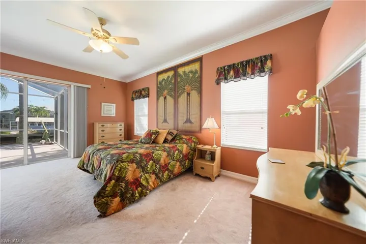 Bedroom featuring access to exterior, crown molding, ceiling fan, and light colored carpet