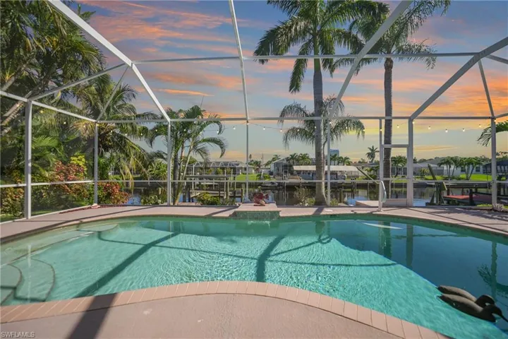 Pool at dusk featuring a lanai