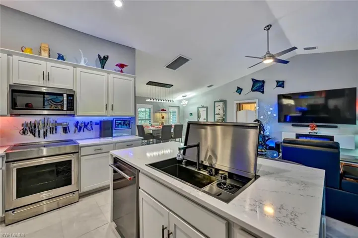 Modern kitchen featuring white cabinetry, a stainless steel appliance suite, and quartz countertops