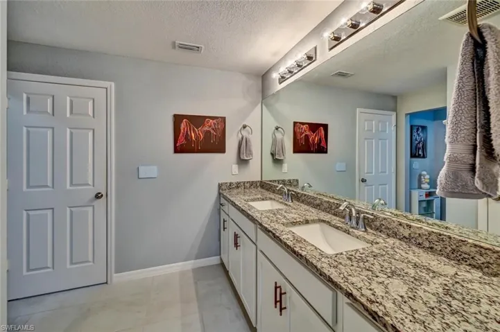 Dual vanity featuring granite countertops and undermount sinks