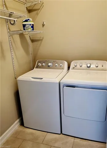 Laundry area with washer and dryer and light tile floors