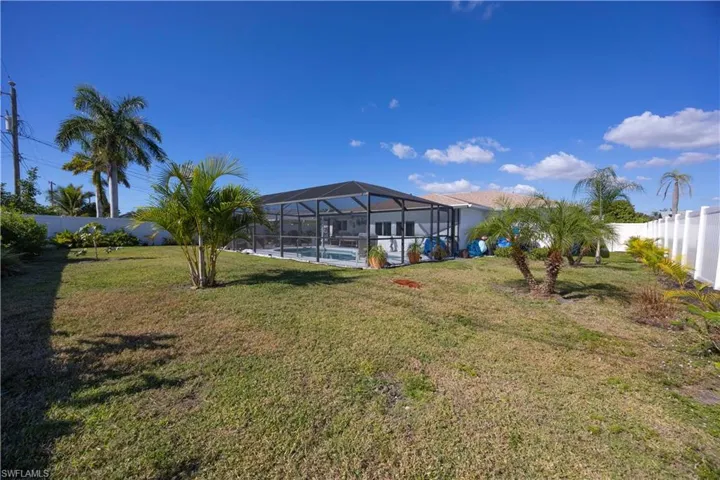 Fenced backyard featuring a sunroom, an outdoor pool, and a lanai