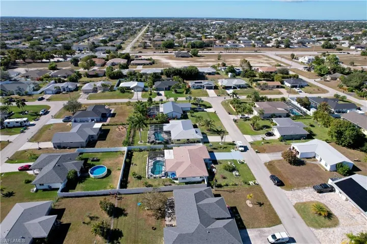 Aerial view of property and surrounding area featuring nearby suburban area