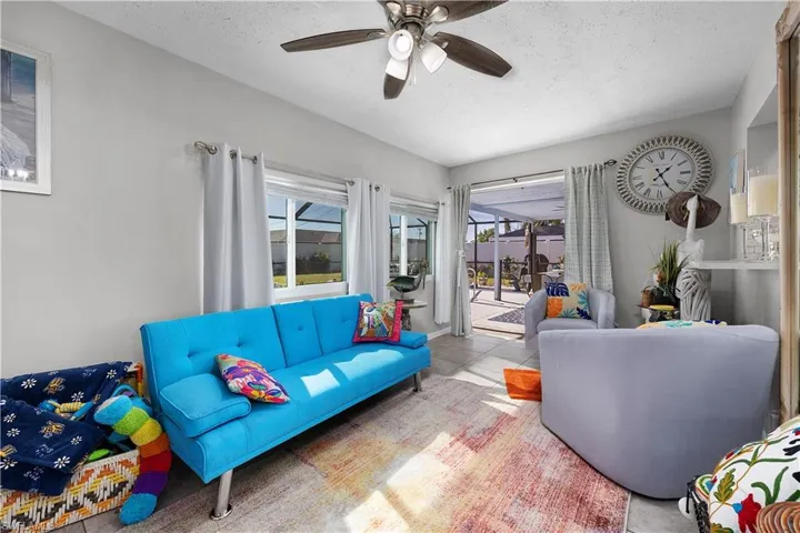 Tiled living room with a textured ceiling and a ceiling fan